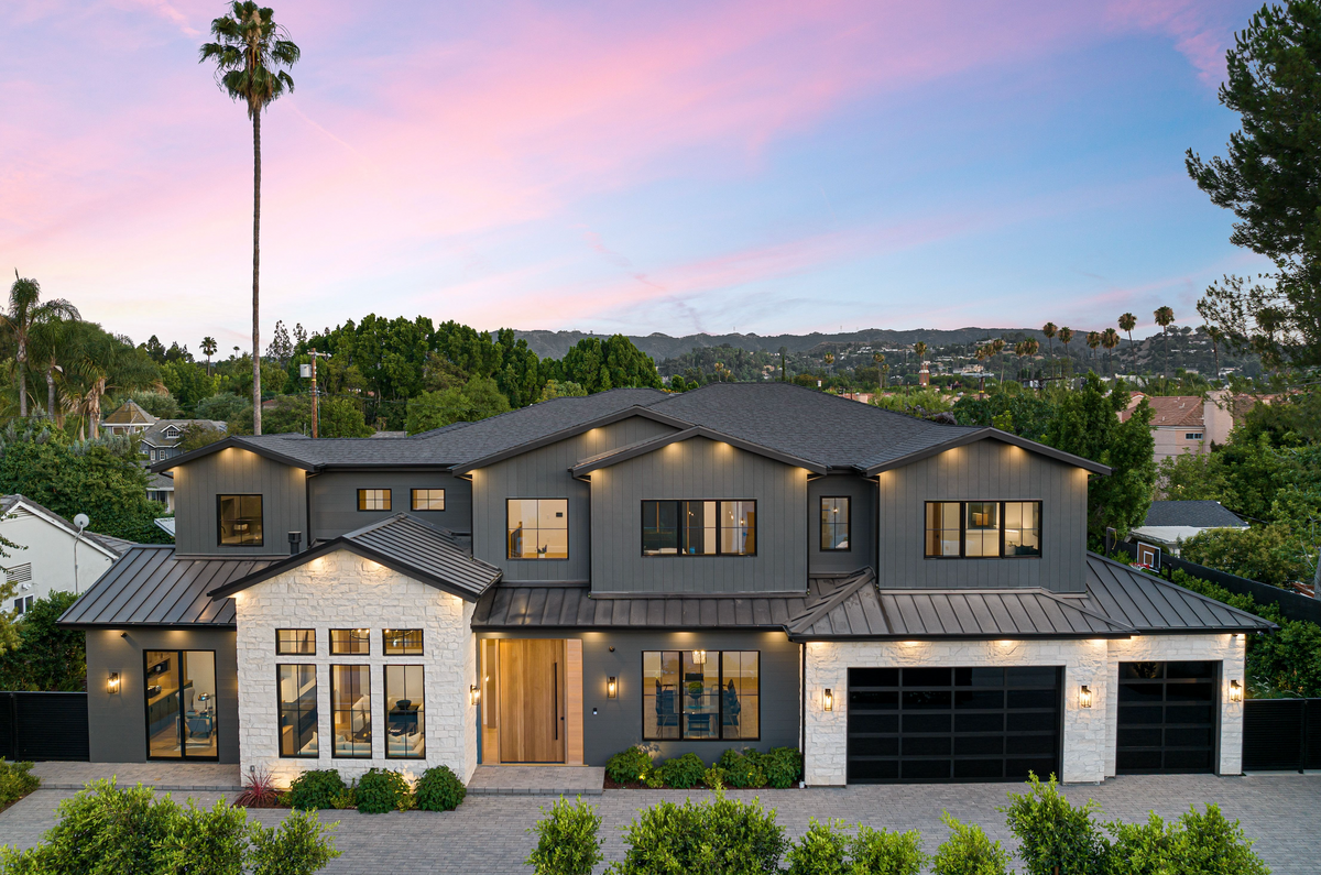 Modern home with a new dark composite roof at sunset
